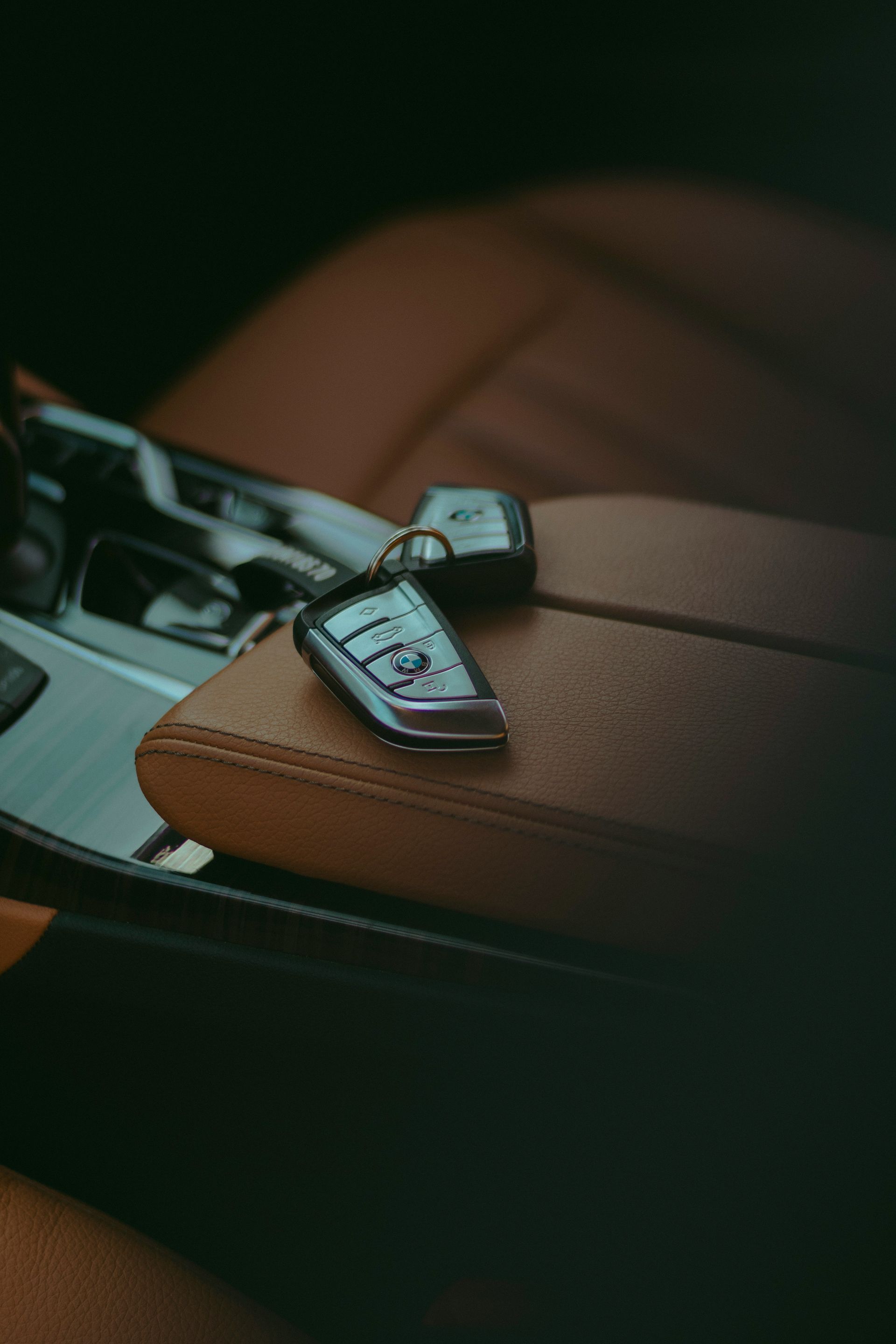 Car keys resting on a leather car seat.